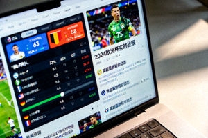 笔记本电脑屏幕上显示着实时体育赛事数据与新闻资讯界面